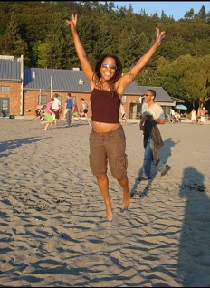 Dr. Karen Hurley on a beach jumping for joy